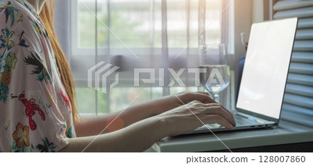 working from home, remote work concept. side view of Asian woman wearing casual shirt using laptop computer for work at home. laptop with blank white screen for copy space working from home, remote work concept. side view of Asian woman wearing casual shirt using laptop computer for work at home. laptop with blank white screen for copy space 128007860