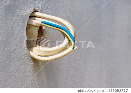 Cables wires sticking out of concrete wall. Cables wires sticking out of concrete wall. 128008717