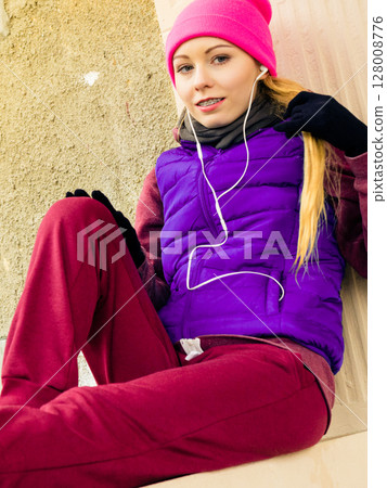Woman wearing warm sportswear relaxing after exercising 128008776