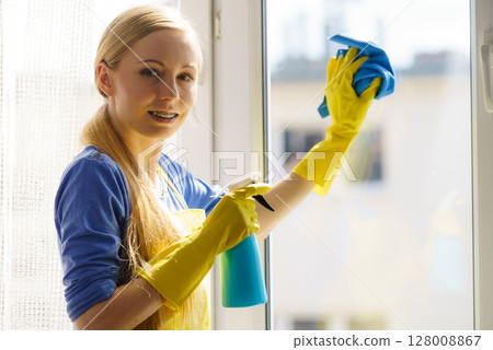 Woman cleaning window at home Woman cleaning window at home 128008867