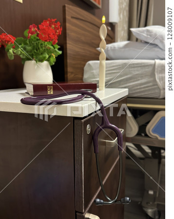 Peaceful Hospice Bedside with Bible, Candle, and Stethoscope 128009107