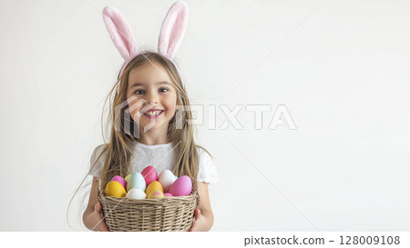 Cute girl with bunny ears holding a basket of colorful Easter eggs against white background Cute girl with bunny ears holding a basket of colorful Easter eggs against white background 128009108