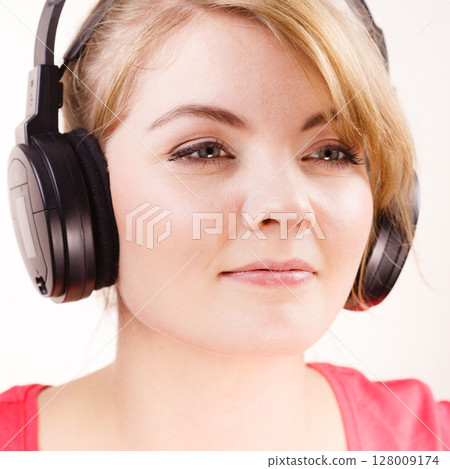 Woman in big headphones listening music Woman in big headphones listening music 128009174
