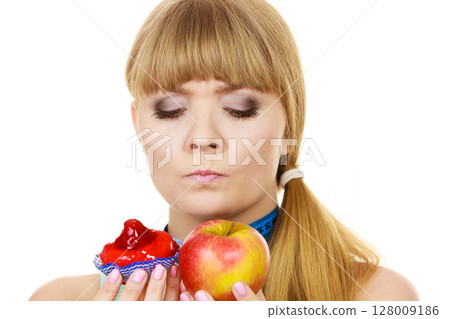 Woman choosing fruit or cake make dietary choice Woman choosing fruit or cake make dietary choice 128009186