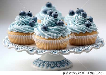 Various cakes in blue tones on dessert stand with soft lighting. 128009279