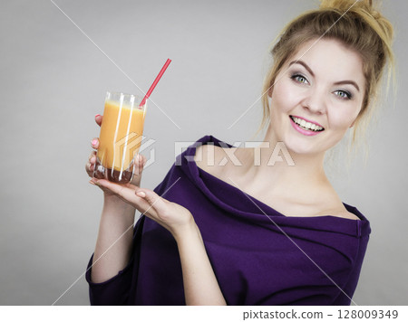 Happy woman holding fresh orange juice Happy woman holding fresh orange juice 128009349
