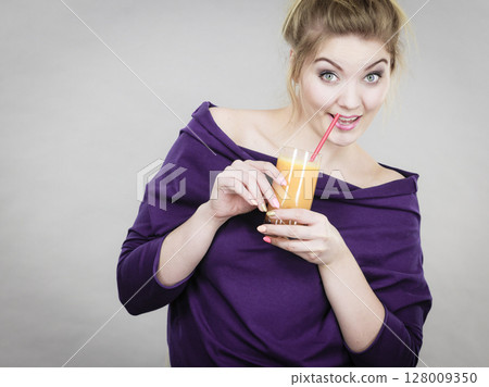 Happy woman holding fresh orange juice Happy woman holding fresh orange juice 128009350