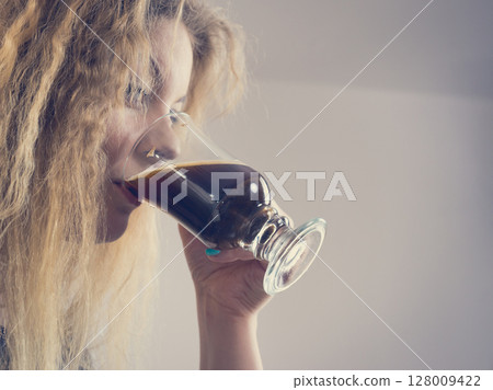 Positive woman drinking her morning coffee 128009422