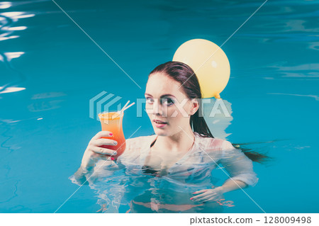 Happy woman with balloons and cocktail in water. 128009498