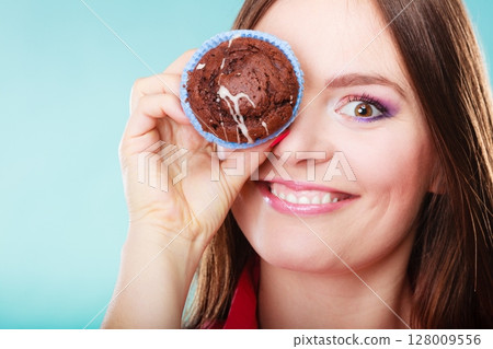 Funny woman holds cake in hand covering her eye 128009556