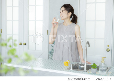 一個女人在廚房喝水 128009927
