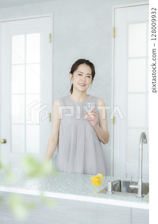 Woman drinking water in the kitchen Woman drinking water in the kitchen 128009932