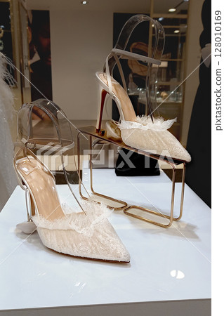 Lace elegant women whites high heel shoes with stylish straps on shop window display 128010169