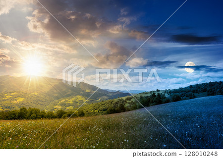 mountain landscape with wide meadow on summer solstice with sun and moon. grass on the pasture rolling through hills in countryside scenery to distant alpine valley. day and night time change concept 128010248