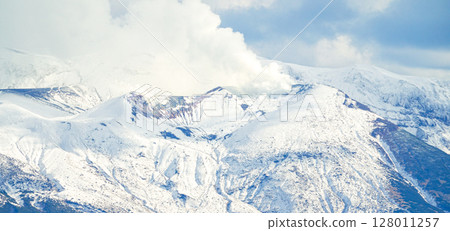 Smoke rising from the snow-capped Tokachi mountain range in Hokkaido Smoke rising from the snow-capped Tokachi mountain range in Hokkaido 128011257