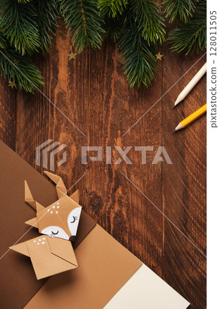 Handmade origami deer, origami paper, and pencils. Space for your text. 128011505