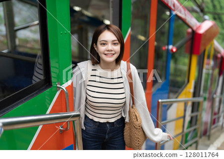 Inbound woman riding a cable car 128011764