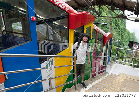 Inbound male riding a cable car Inbound male riding a cable car 128011778