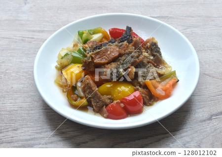deep fried slice mango fish with bell pepper and onion in black pepper sauce on plate  128012102
