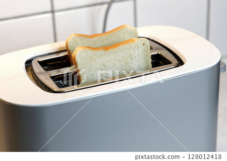 Toaster with two pieces of roasted bread Toaster with two pieces of roasted bread 128012418