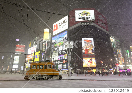 Winter Sapporo: A tram passing through Susukino intersection at night 128012449
