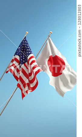 Two flags, American and Japanese, wave against clear blue sky, symbolizing international relations 128012803
