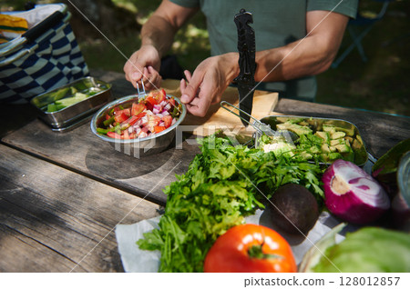 Preparing a Fresh Vegetable Salad Outdoors with Vibrant Ingredients Preparing a Fresh Vegetable Salad Outdoors with Vibrant Ingredients 128012857