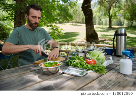 Man Preparing Fresh Salad Outdoors on a Sunny Day Man Preparing Fresh Salad Outdoors on a Sunny Day 128012890