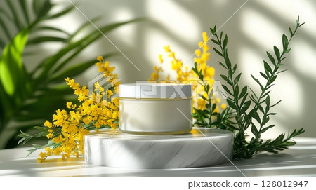 A jar of face cream placed on top of a marble pedestal, surrounded by yellow flowers and green plants.  128012947