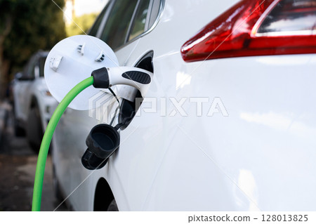 Electric car charging close up. Renewable clean energy car for progressive eco awareness lifestyle . 128013825