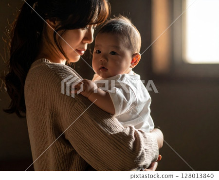 A woman holding a baby 128013840