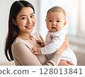 A woman holding a baby 128013841