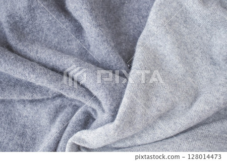 Cashmere gray fabric, top view. Draped, texture, background. Natural wool clothing. Cashmere gray fabric, top view. Draped, texture, background. Natural wool clothing. 128014473