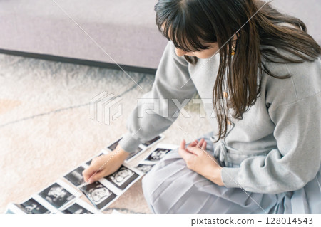 一名孕婦正在看超音波影像,期待寶寶的出生 一名孕婦正在看超音波影像,期待寶寶的出生 128014543