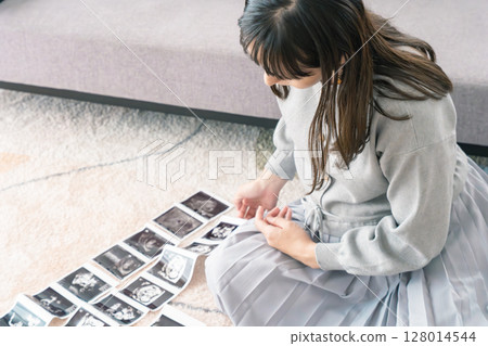 一名孕婦正在看超音波影像,期待寶寶的出生 一名孕婦正在看超音波影像,期待寶寶的出生 128014544
