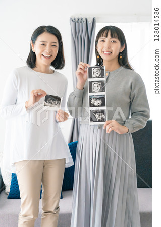 母親和女兒正在查看超音波影像，熱切地等待寶寶的出生 128014586