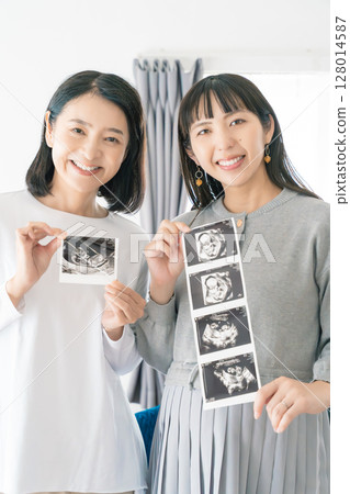 母親和女兒正在查看超音波影像，熱切地等待寶寶的出生 128014587