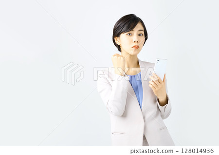 Business woman operating a smartphone in front of a white background 128014936