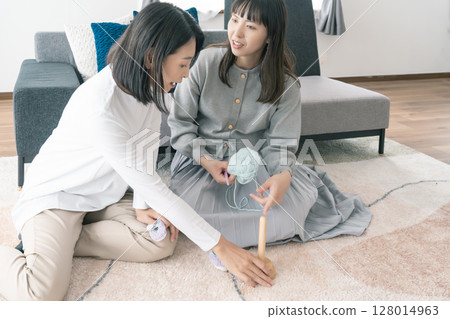 母親和女兒織嬰兒鞋 母親和女兒織嬰兒鞋 128014963