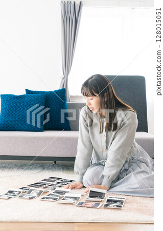 A pregnant woman looking at an ultrasound image and looking forward to the birth of her baby A pregnant woman looking at an ultrasound image and looking forward to the birth of her baby 128015051