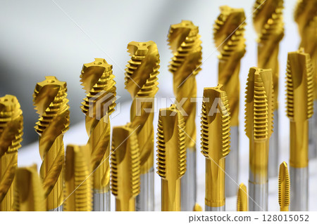 Close up scene the golden coating spiral tap tool for CNC machine. Close up scene the golden coating spiral tap tool for CNC machine. 128015052