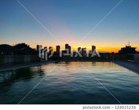 Outdoor pool sunset 128015238