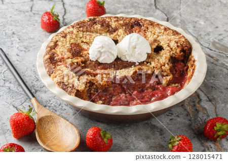Strawberry cobbler pie with ice cream close-up in baking dish. Horizontal 128015471
