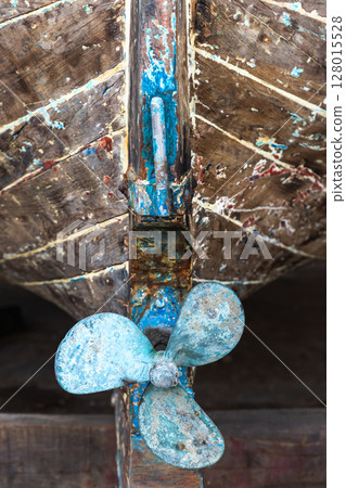 Close-up image of an old wooden boat displaying its weathered propeller Close-up image of an old wooden boat displaying its weathered propeller 128015528