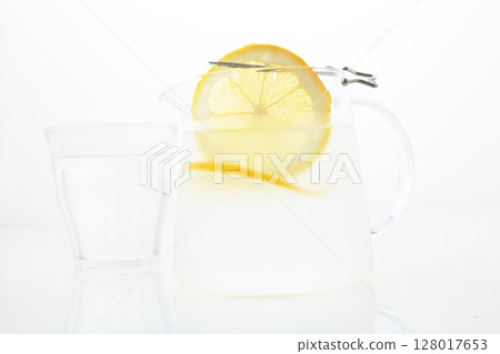 Meyer lemon cut into pieces and a pitcher of lemon water 128017653