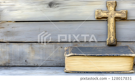 A wooden background with space featuring a cross resting on an aged book, symbolizing faith and reflection 128017831