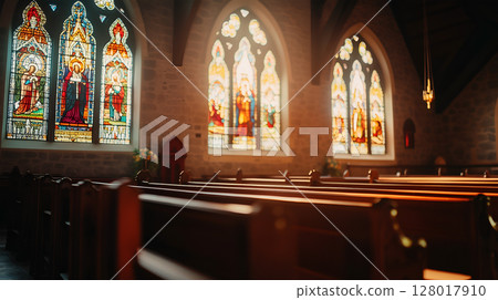 Stained glass windows illuminating a quiet church interior during morning light 128017910