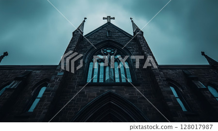 A dramatic view of a gothic church with intricate stained glass against a moody sky 128017987