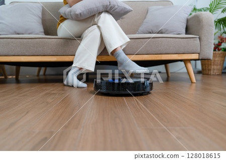 Young modern Asian woman doing house cleaning at home. Confident and independent homemaker maintaining a clean, stylish living space. 128018615