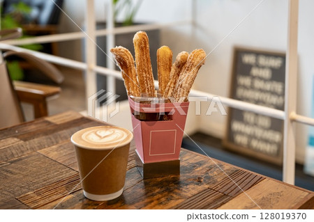 在時尚的咖啡館享用油條和咖啡 在時尚的咖啡館享用油條和咖啡 128019370